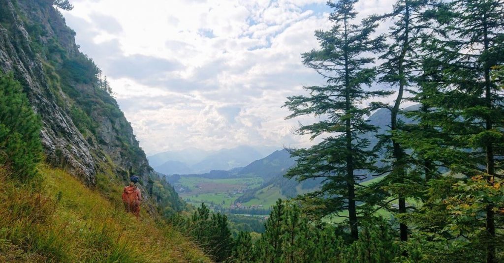 Frau mi Rrucksack in den sommerlichen Bergen Kaiserwinkl mit Blick auf das Kaisergebirge